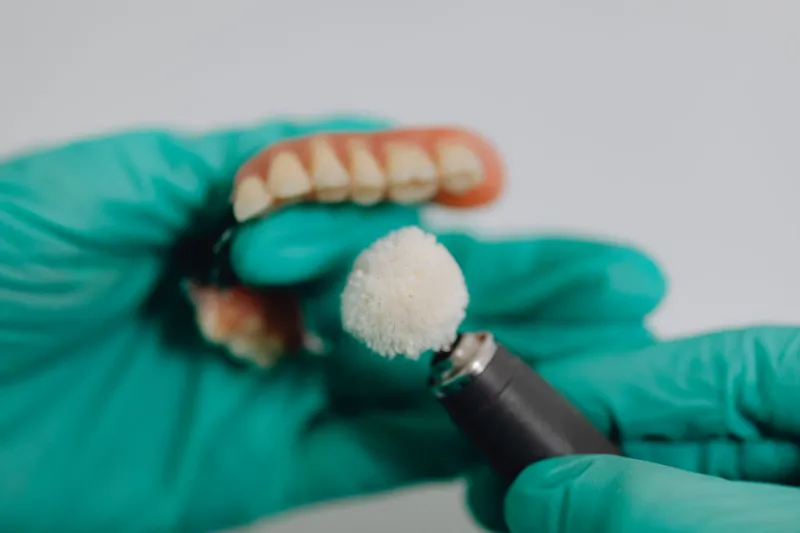 A dentist preparing a denture